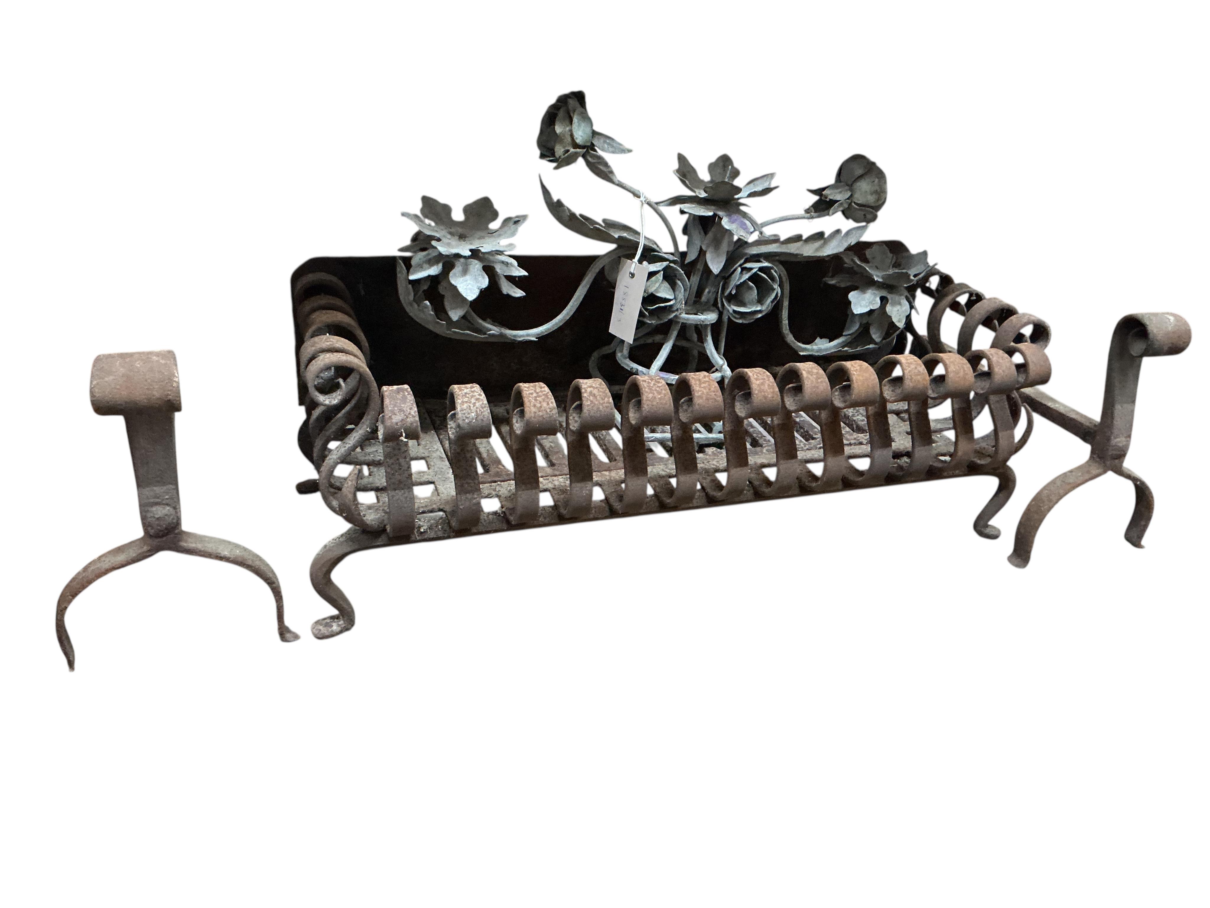 A wrought iron fire grate, dogs and a metal pricket candle holder